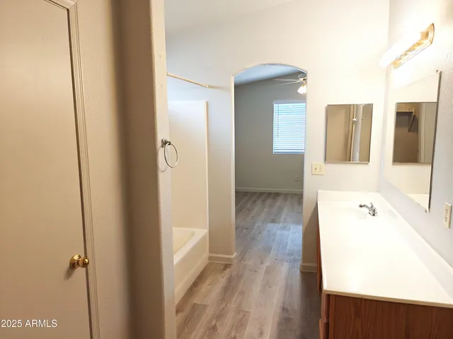 a bathroom with a tub sink and mirror