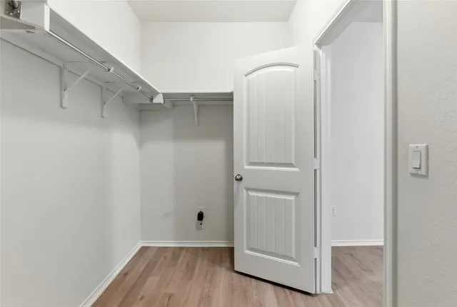 a view of walk in closet with wooden floor
