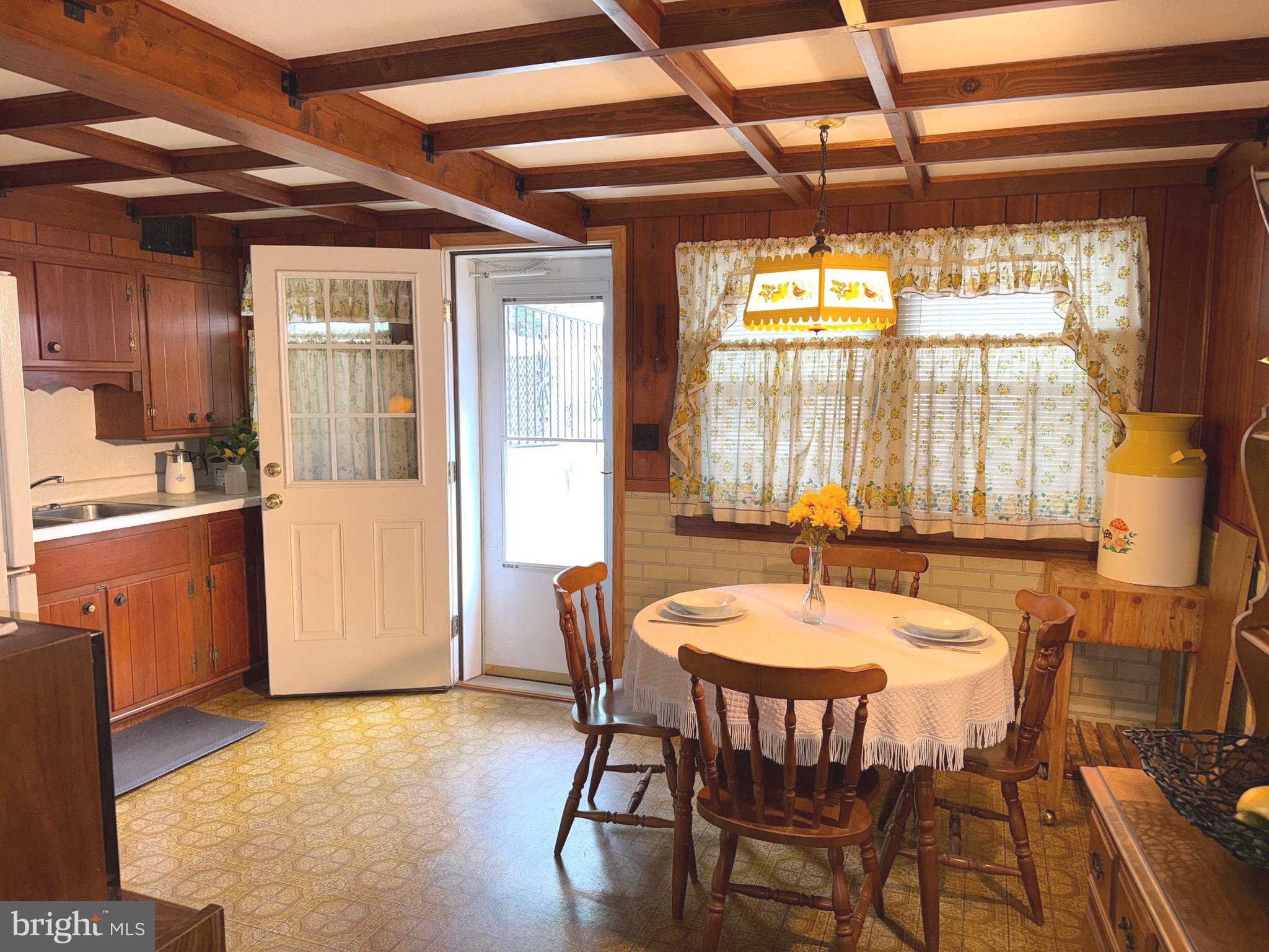 8144 Gray Haven Road Baltimore, MD 21222 - Photo 17 of 37 a dining room with wooden floor a chandelier a wooden table and chairs
