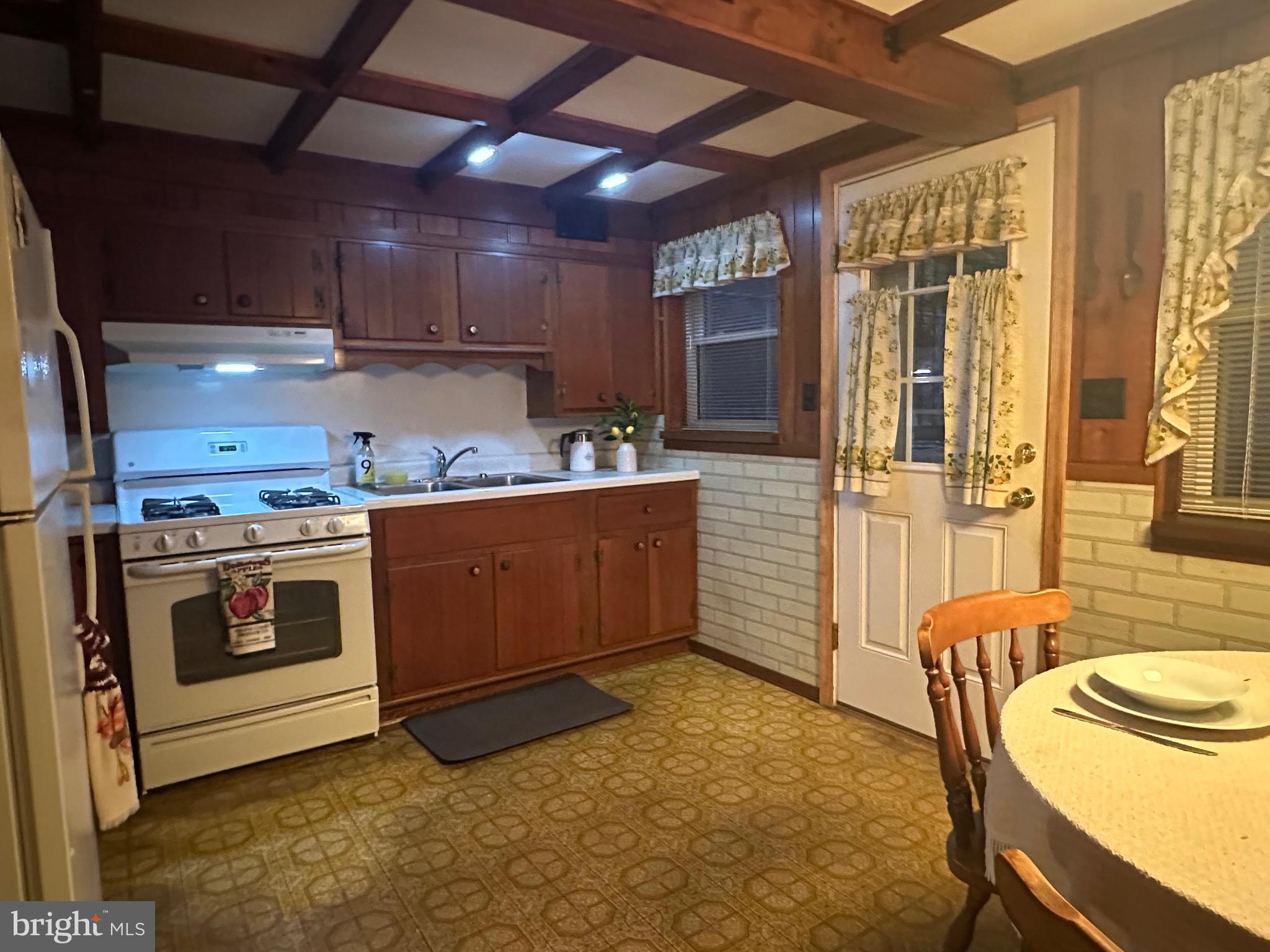 8144 Gray Haven Road Baltimore, MD 21222 - Photo 36 of 37 a kitchen with a stove a sink and a refrigerator