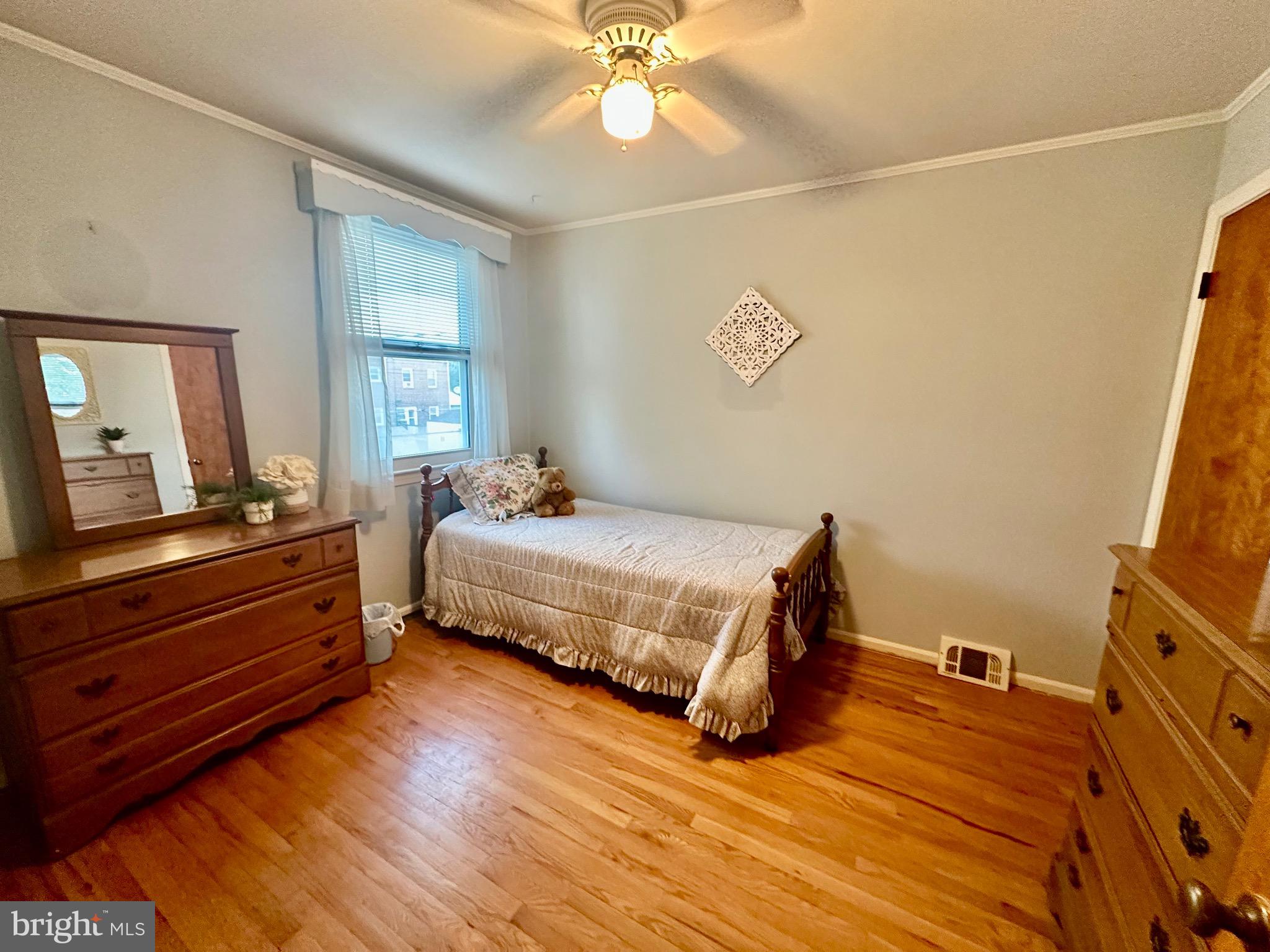 8144 Gray Haven Road Baltimore, MD 21222 - Photo 8 of 37 a bedroom with a bed and a flat tv screen on dresser