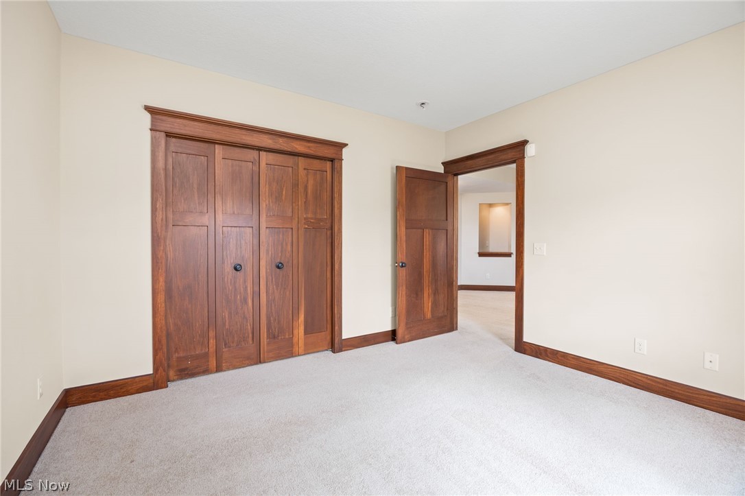 6925 River Styx Road Medina, OH 44256 - Photo 34 of 49 Room featuring light-colored carpeting, warm-toned wall paint, and dark wood-finish trim