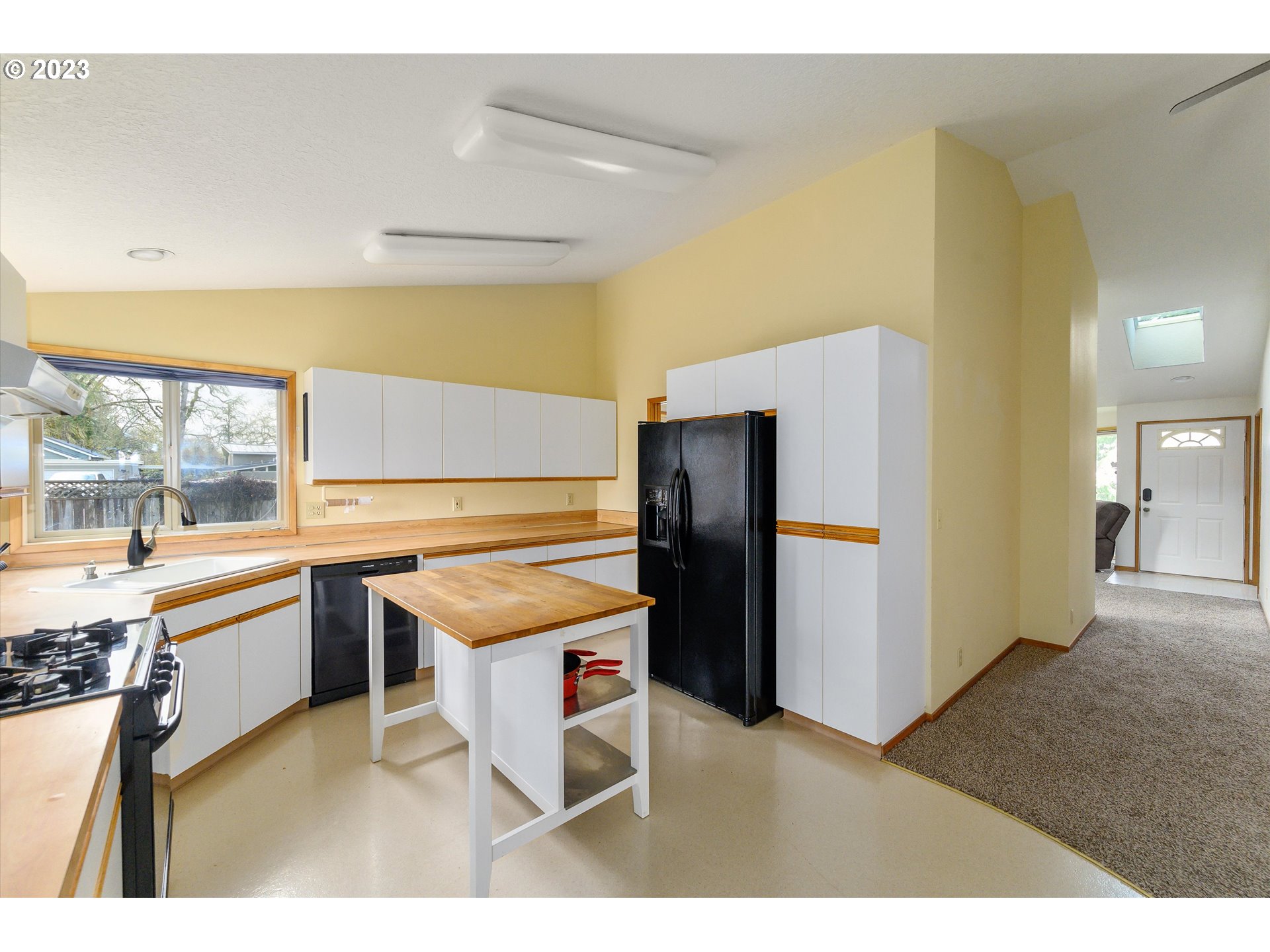 1811 D Street Forest Grove, OR 97116 - Photo 14 of 34 a kitchen with stainless steel appliances kitchen island granite countertop a refrigerator and a sink