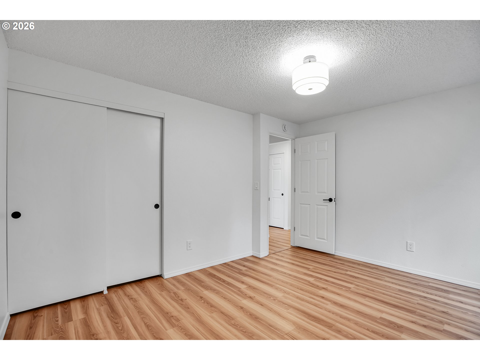 20332 Southwest Rock Court Beaverton, OR 97003 - Photo 37 of 47 a view of an empty room with wooden floor and a chandelier
