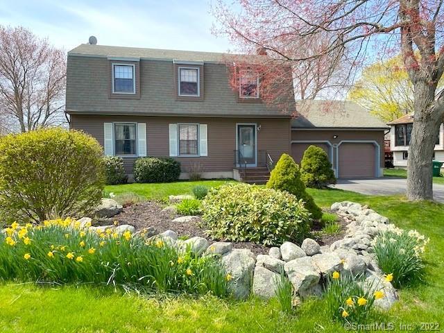natural stone and beautiful landscaping add to the charm of this gambrel colonial