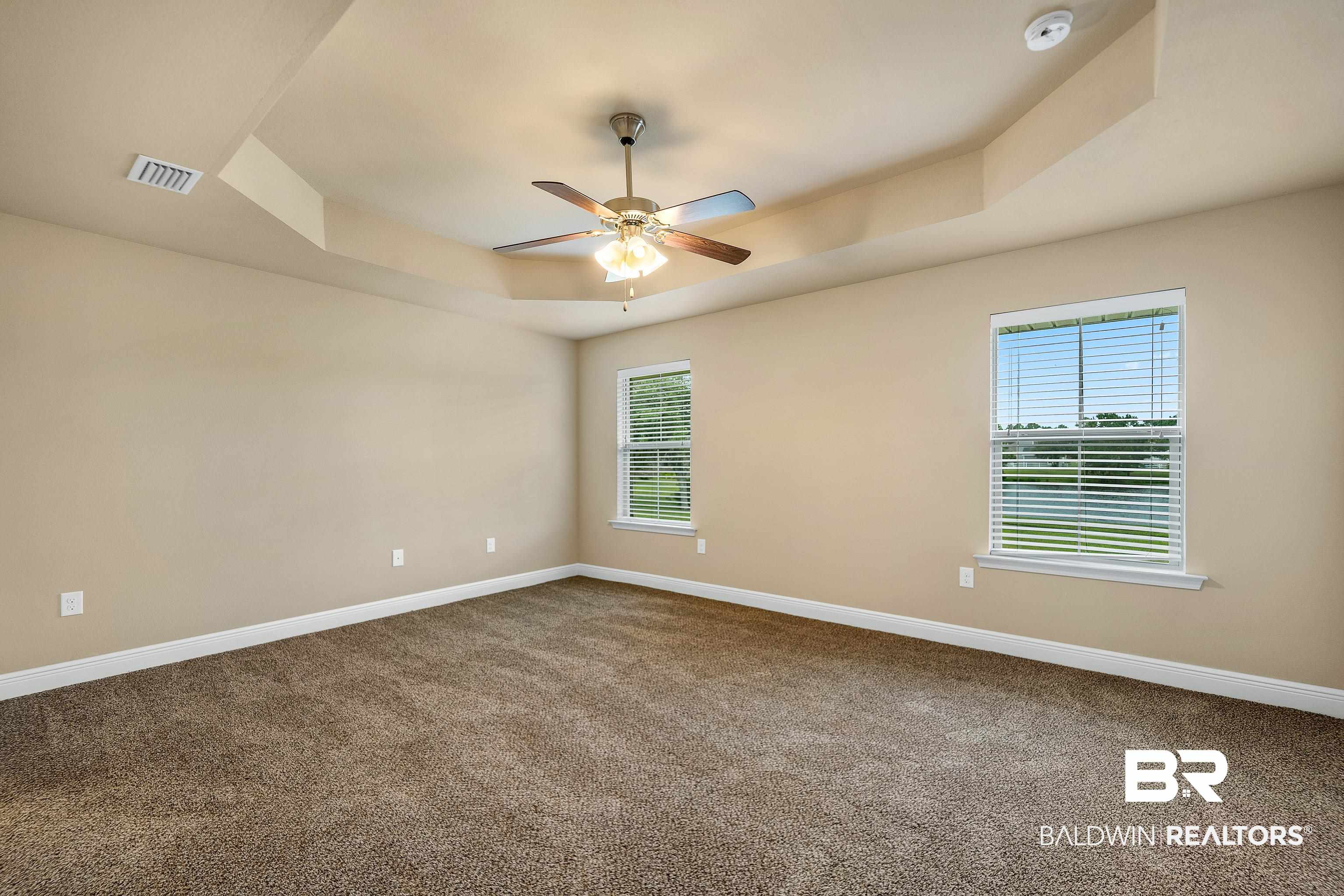 22631 Lake South Drive Foley, AL 36535 - Photo 11 of 25 Spare room with a raised ceiling, carpet flooring, and ceiling fan