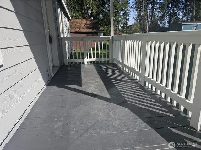 a view of a balcony with wooden floor and fence
