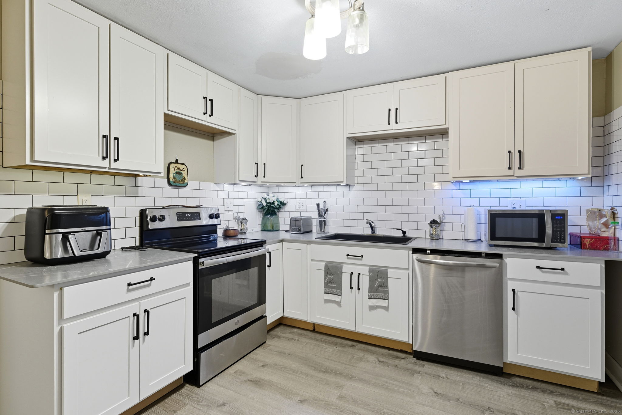 41 Chestnut Drive Windsor, CT 06095 - Photo 14 of 27 a kitchen with cabinets stainless steel appliances a sink and wooden floor