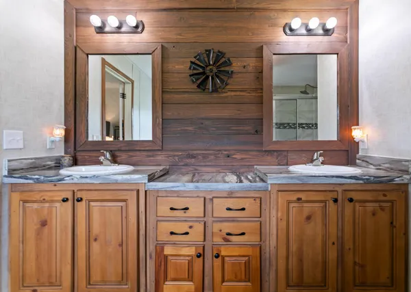 a bathroom with a granite countertop tub sink and mirror