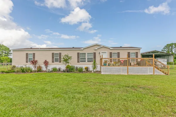 a view of a house with a yard and wooden fence