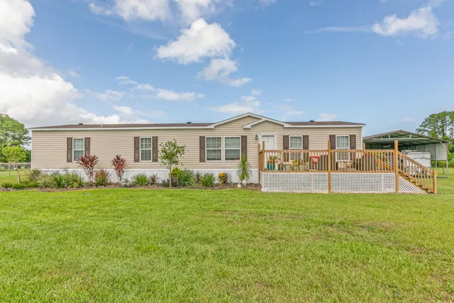 a view of a house with a yard and wooden fence