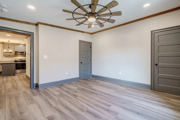 an empty room with wooden floor and chandelier
