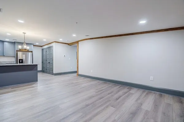 a view of kitchen with refrigerator and wooden floor