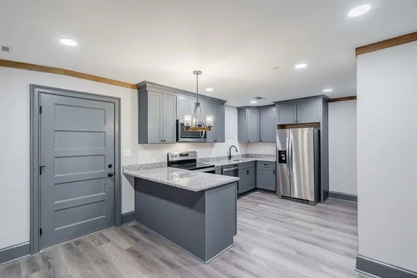 a kitchen with stainless steel appliances a stove a refrigerator and cabinets