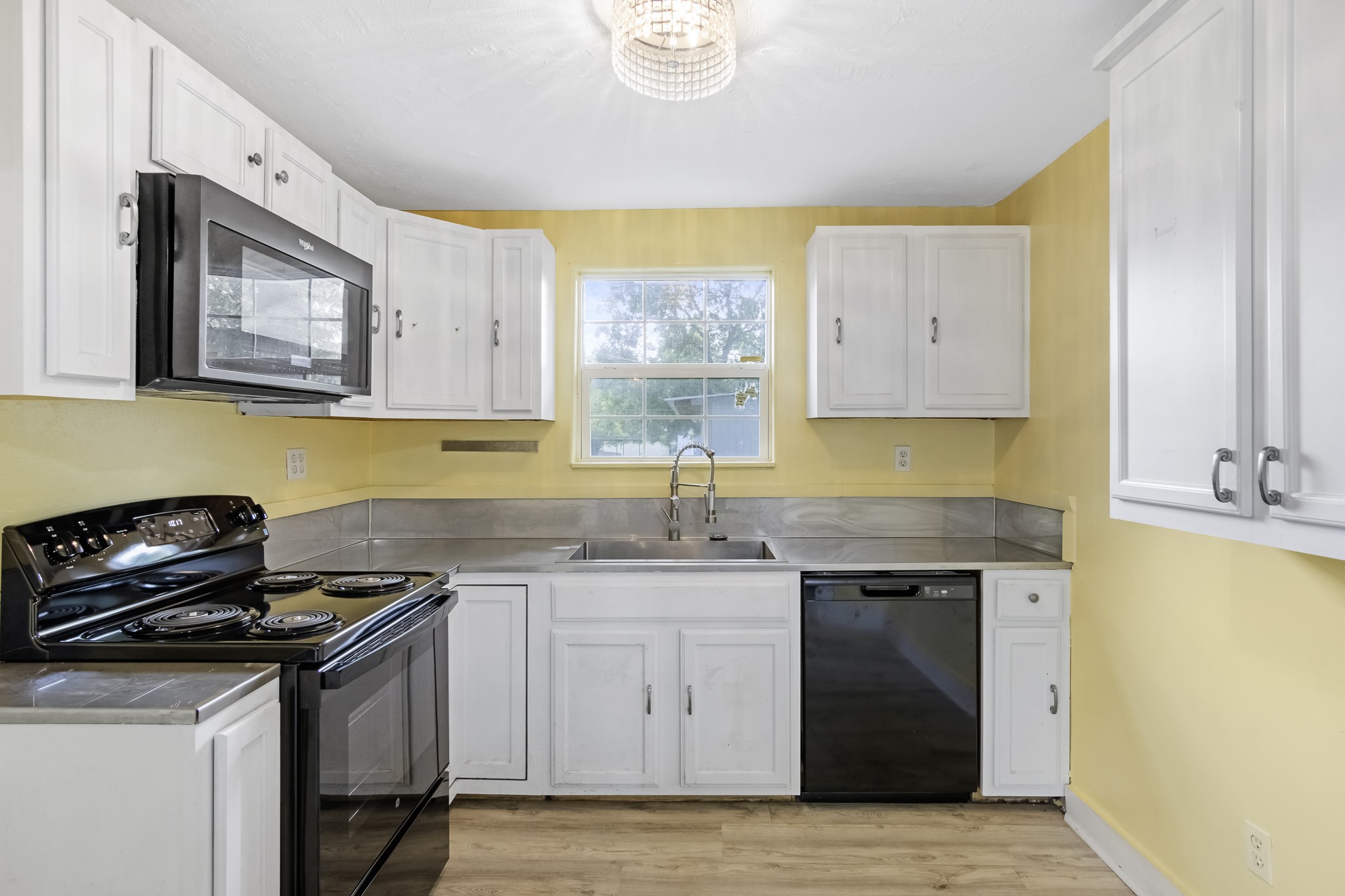 1200 4th Street Palacios, TX 77465 - Photo 15 of 44 a kitchen with stainless steel appliances granite countertop a sink and a stove next to a window