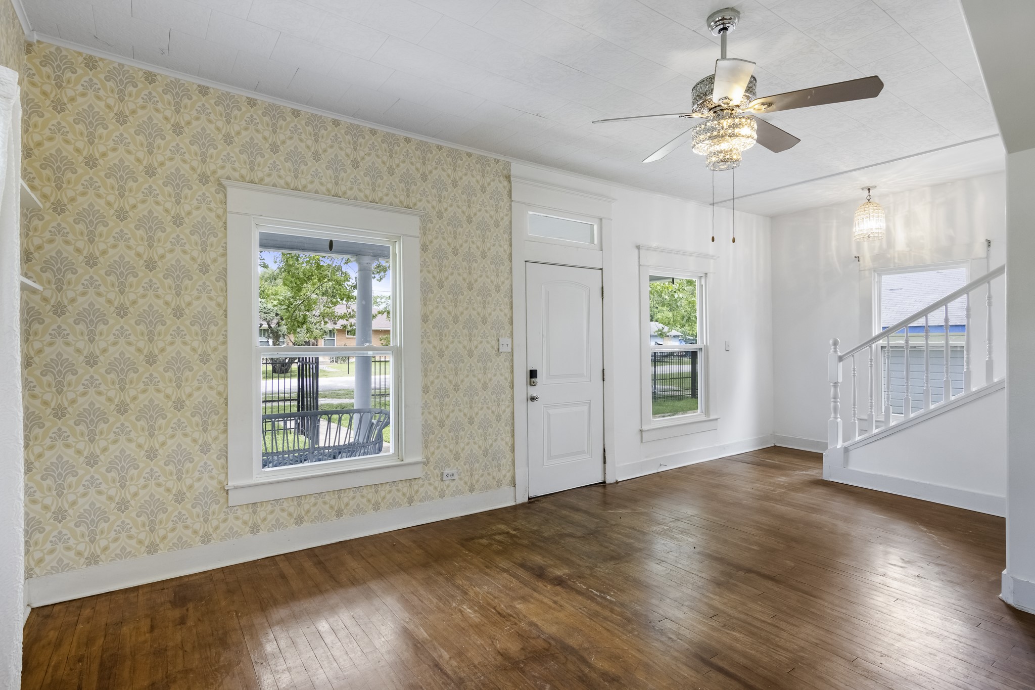 1200 4th Street Palacios, TX 77465 - Photo 7 of 44 an empty room with wooden floor chandelier fan and windows
