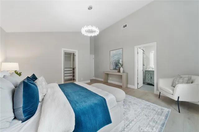 a bedroom with a bed and a chandelier