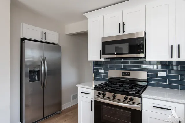 a kitchen with stainless steel appliances kitchen island granite countertop a stove a refrigerator and a microwave