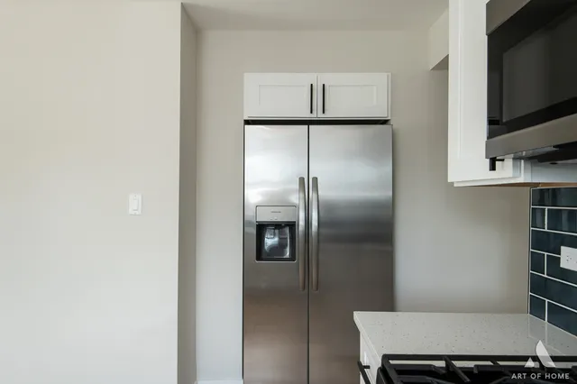 a room with a refrigerator and cabinets