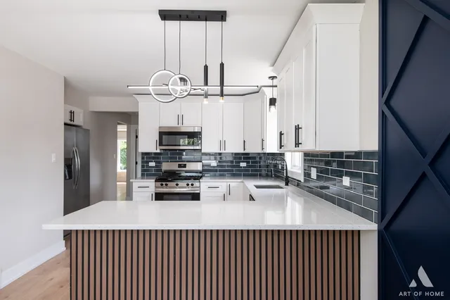a kitchen with cabinets stainless steel appliances a sink and a stove