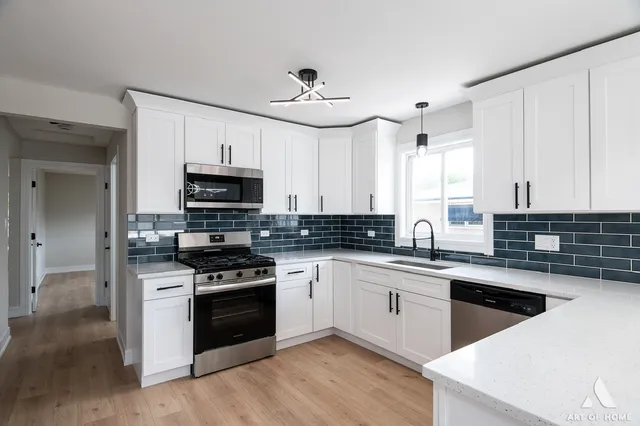 a kitchen with white cabinets and appliances