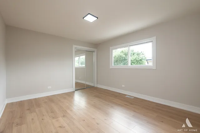 a bedroom with a large bed a potted plant and a window