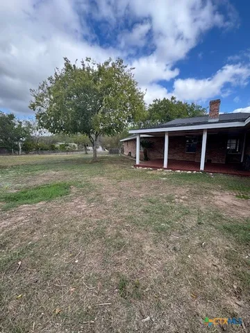 a view of a backyard with wooden fence