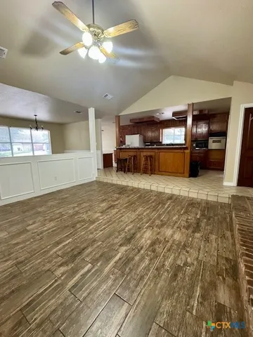 a view of a kitchen with kitchen island a sink stainless steel appliances and a counter top space