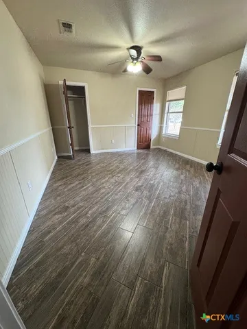 a view of empty room with window and wooden floor