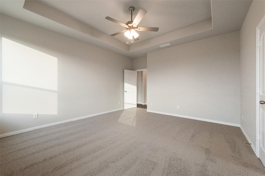 1230 County Road 200 Valley View, TX 76272 - Photo 15 of 26 Carpeted spare room featuring a tray ceiling and a ceiling fan