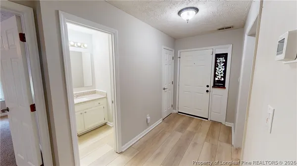 a view of a hallway with wooden floor and closet area