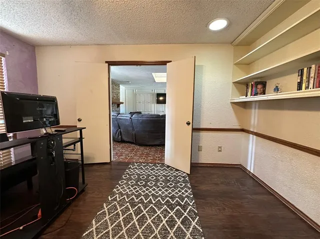 a view of a hallway with wooden floor and furniture