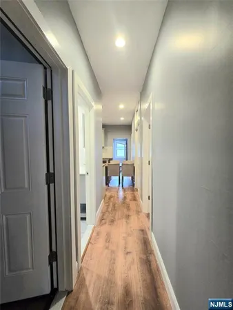 a view of a hallway with a dining room and wooden floor