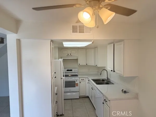 a kitchen with stainless steel appliances a sink a stove a refrigerator and cabinets
