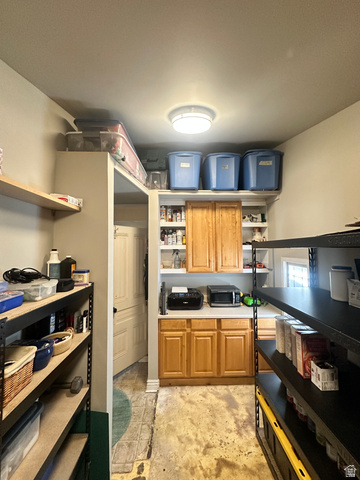 541 300 North Provo, UT 84606 - Photo 27 of 36 Utility room featuring built-in cabinetry, white countertops, wall-mounted shelving, and a flush-mount ceiling light fixture