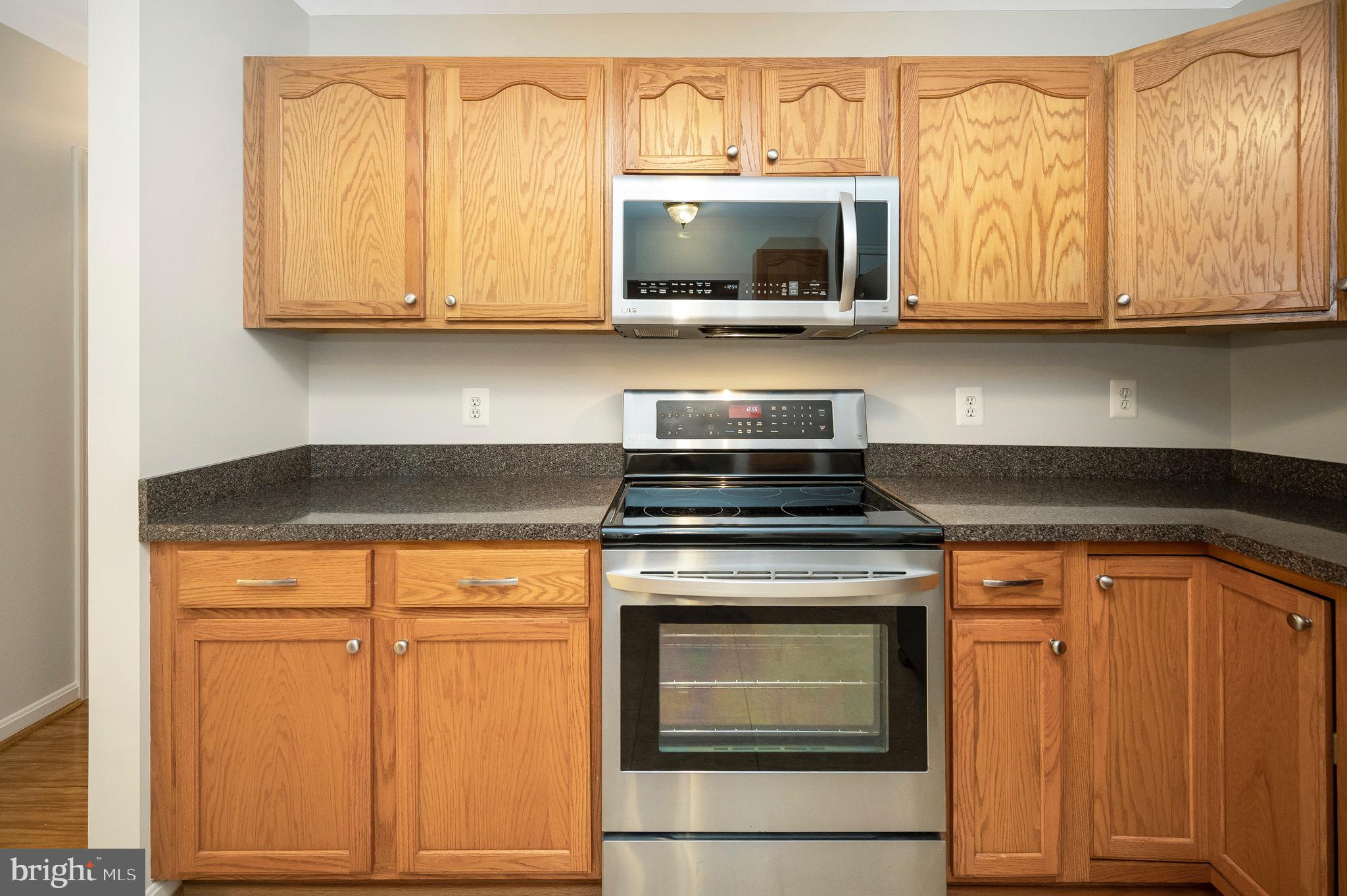 502 Monticello Circle Locust Grove, VA 22508 - Photo 11 of 45 a kitchen with granite countertop a stove top oven microwave and cabinets