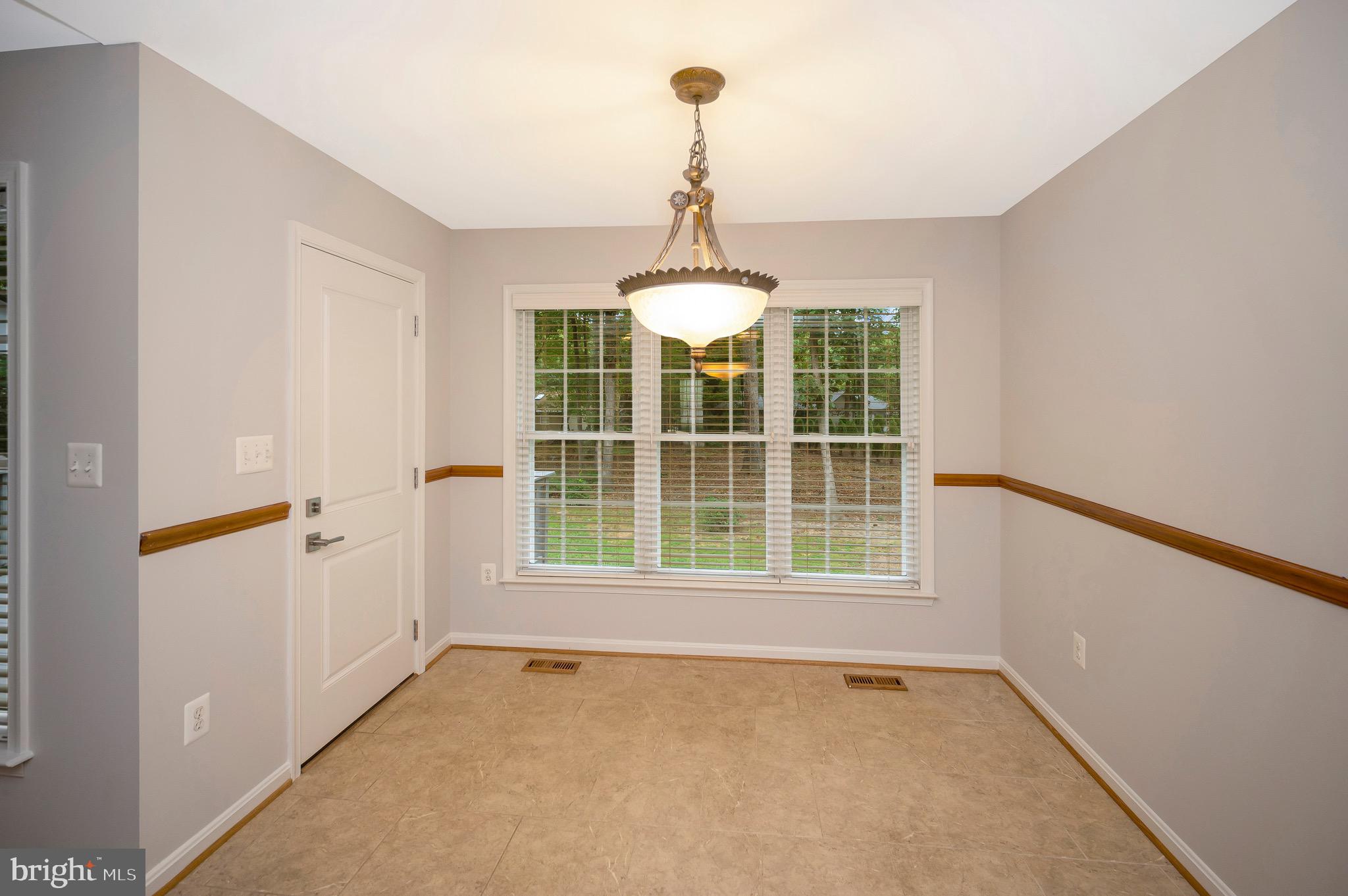 502 Monticello Circle Locust Grove, VA 22508 - Photo 13 of 45 an empty room with a window and chandelier