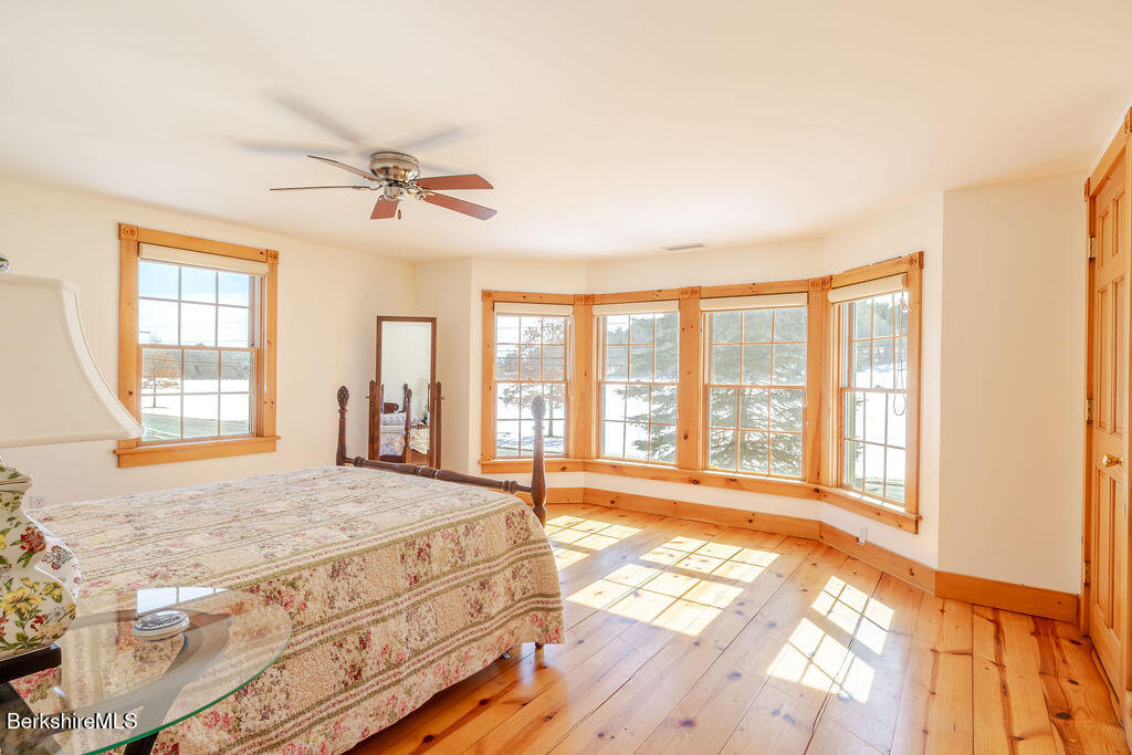 54 Egremont Plain Road Great Barrington, MA 01230 - Photo 28 of 48 a spacious bedroom with a large bed and a chandelier