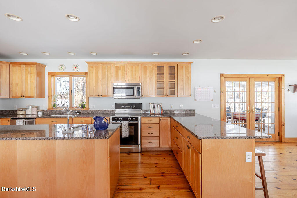 54 Egremont Plain Road Great Barrington, MA 01230 - Photo 3 of 48 a kitchen with stainless steel appliances granite countertop a stove top oven a sink a dining table and chairs