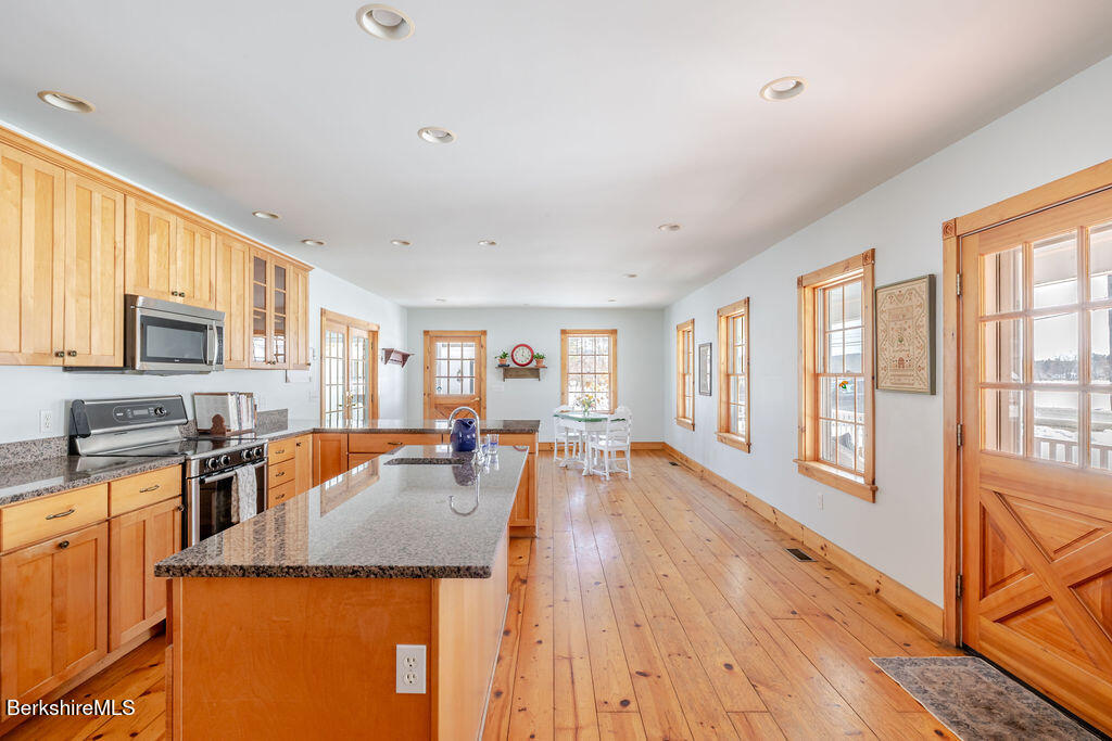 54 Egremont Plain Road Great Barrington, MA 01230 - Photo 6 of 48 a living room with stainless steel appliances granite countertop furniture a refrigerator a stove top oven and a dining table with wooden floor