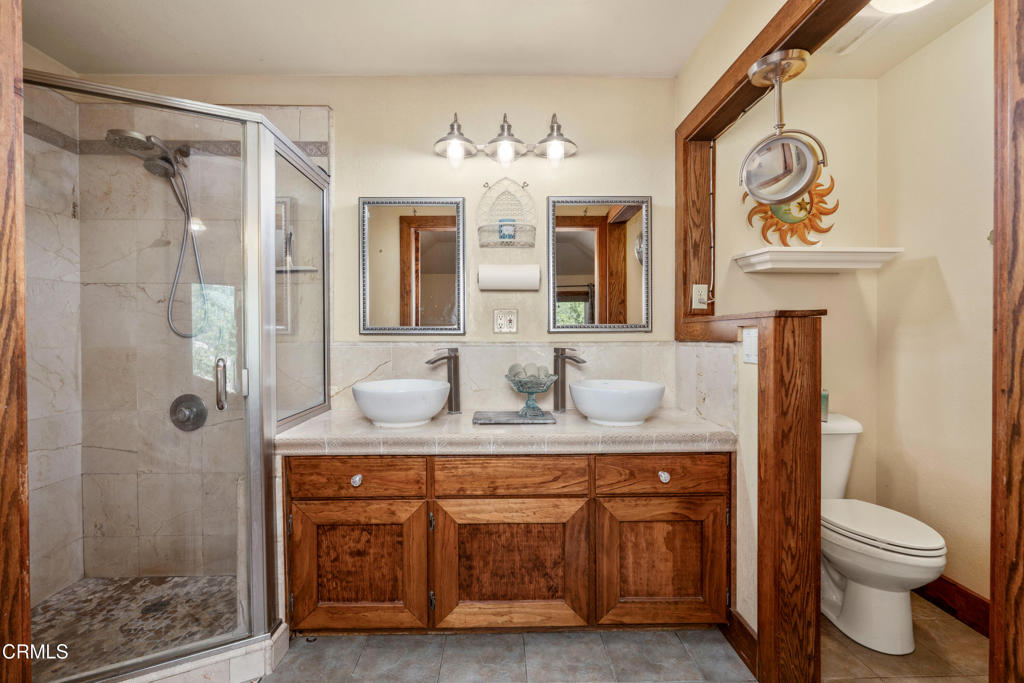 51793 Quail Ridge Road Oakhurst, CA 93644 - Photo 34 of 70 a bathroom with a granite countertop sink a toilet and shower