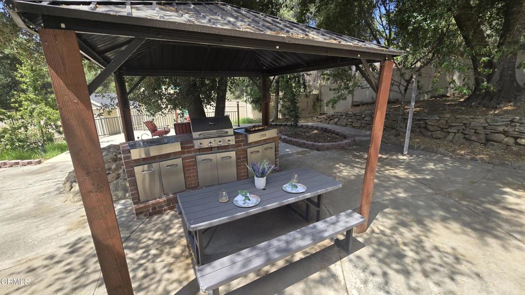 51793 Quail Ridge Road Oakhurst, CA 93644 - Photo 57 of 70 a view of a patio with table and chairs under an umbrella