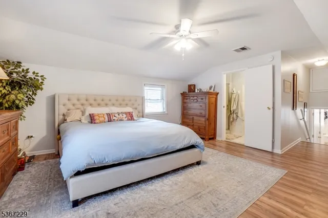 a spacious bedroom with a bed and a chandelier