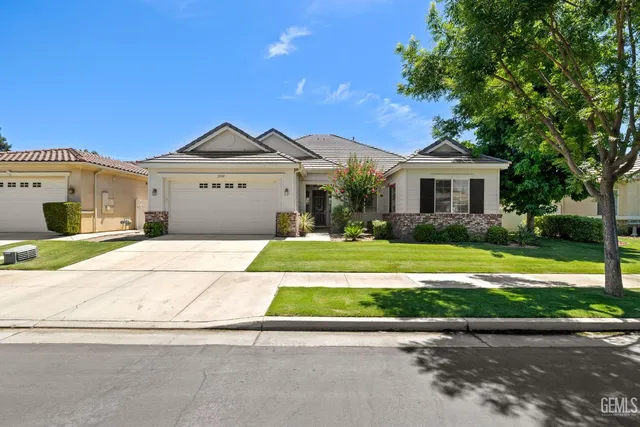 a front view of a house with a garden and trees