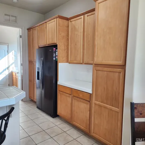 a kitchen with stainless steel appliances granite countertop a stove a sink dishwasher and a refrigerator with wooden floor