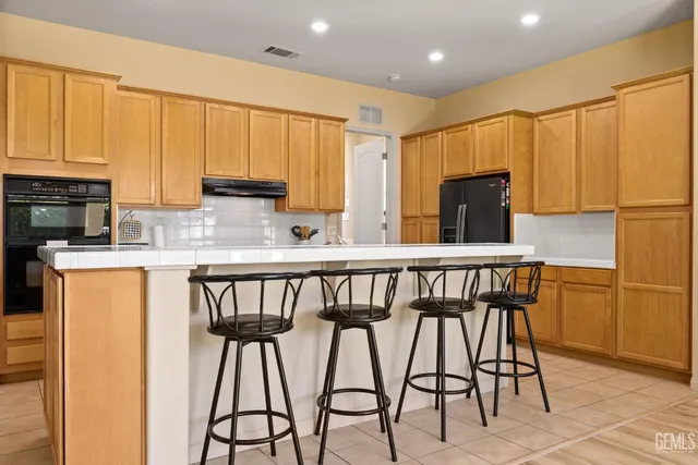 a kitchen with a sink a stove top oven and refrigerator