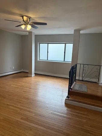 a view of staircase with a floor to ceiling window and wooden floor