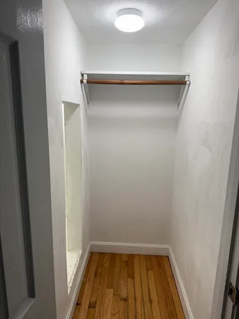 a small space with wooden floor and a window