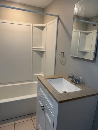 a bathroom with a granite countertop sink and a mirror
