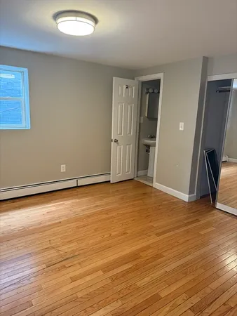 an empty room with wooden floor and a ceiling fan
